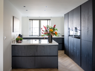 Strakke zwarte keuken met composiet werkblad in Dordrecht Moderne zwarte keuken in Dordrecht